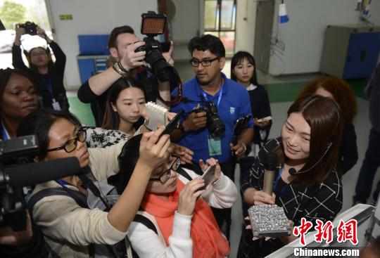 境外媒體記者被剛剛用3D打印出來的義齒金屬基底所吸引。　楊華峰　攝